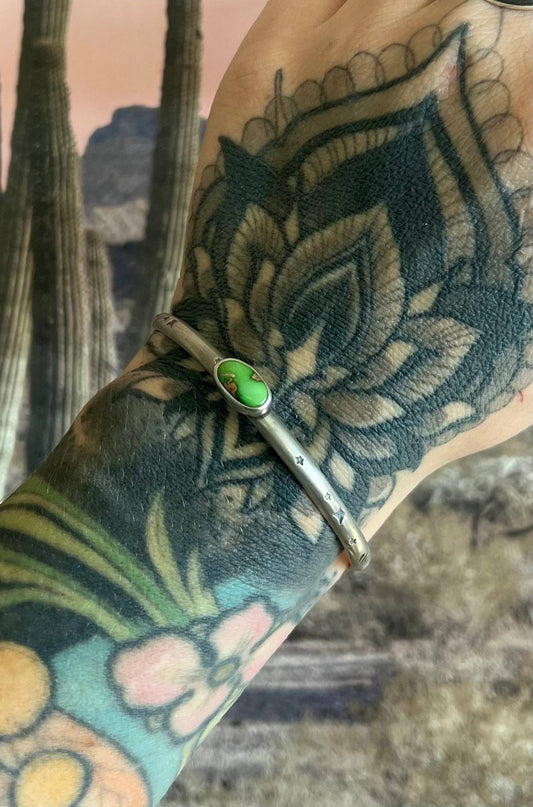 Sonoran Gold Turquoise Cuff in sterling silver on tattooed wrist, featuring a green turquoise stone. Best for S/M wrist sizes.