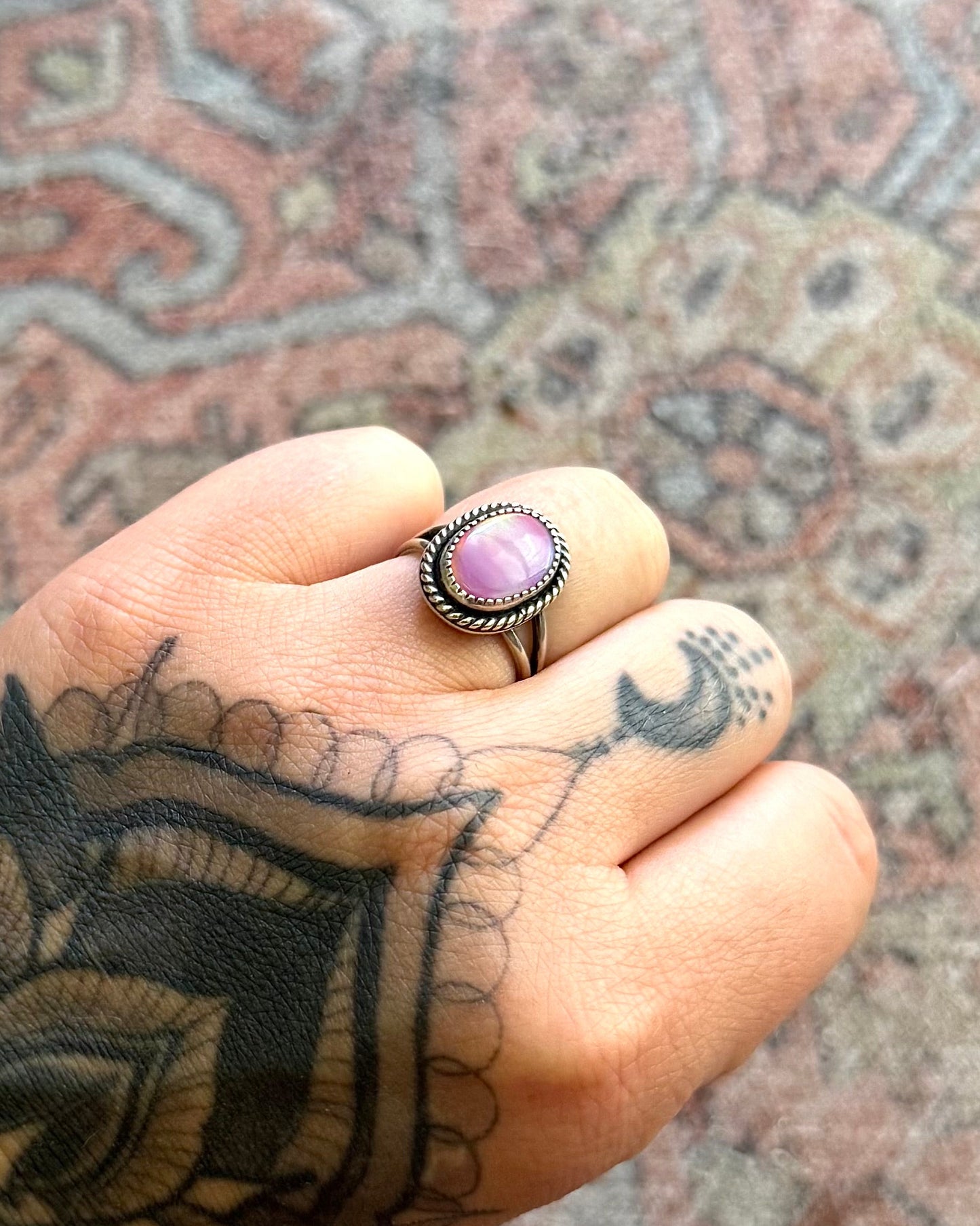 Person's foot with tattoos on a patterned rug